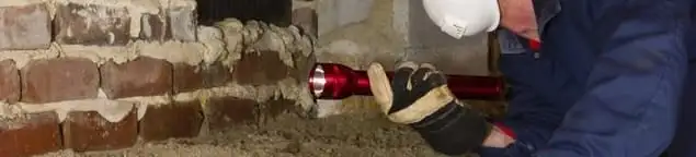 Pest control technician inspecting a crawl space for ant activity and entry points in Jackson, MS
