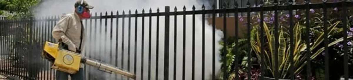Mosquito control technician fogging a yard perimeter for mosquito reduction in Jackson, MS